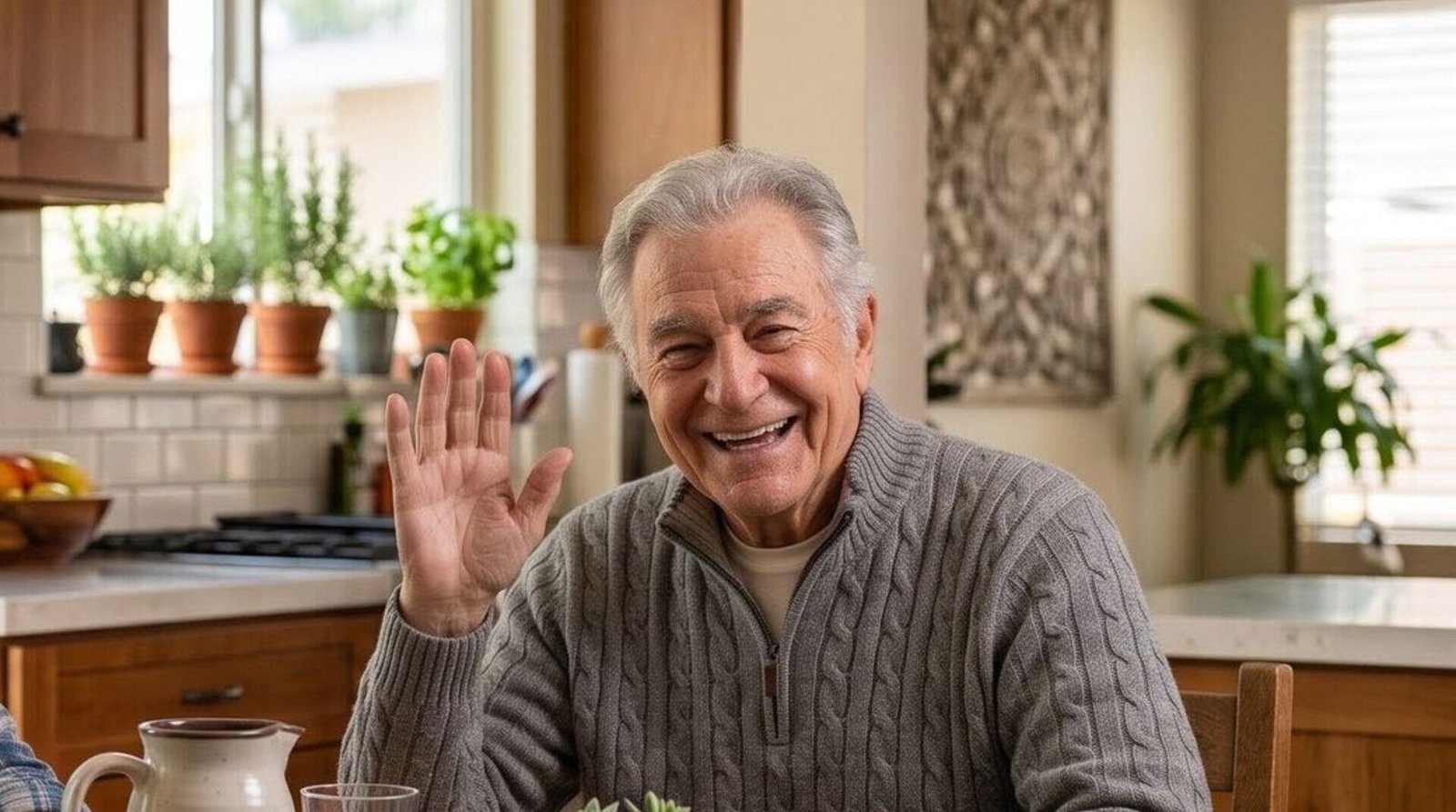 A friendly senior smiling warmly at his kitchen table.